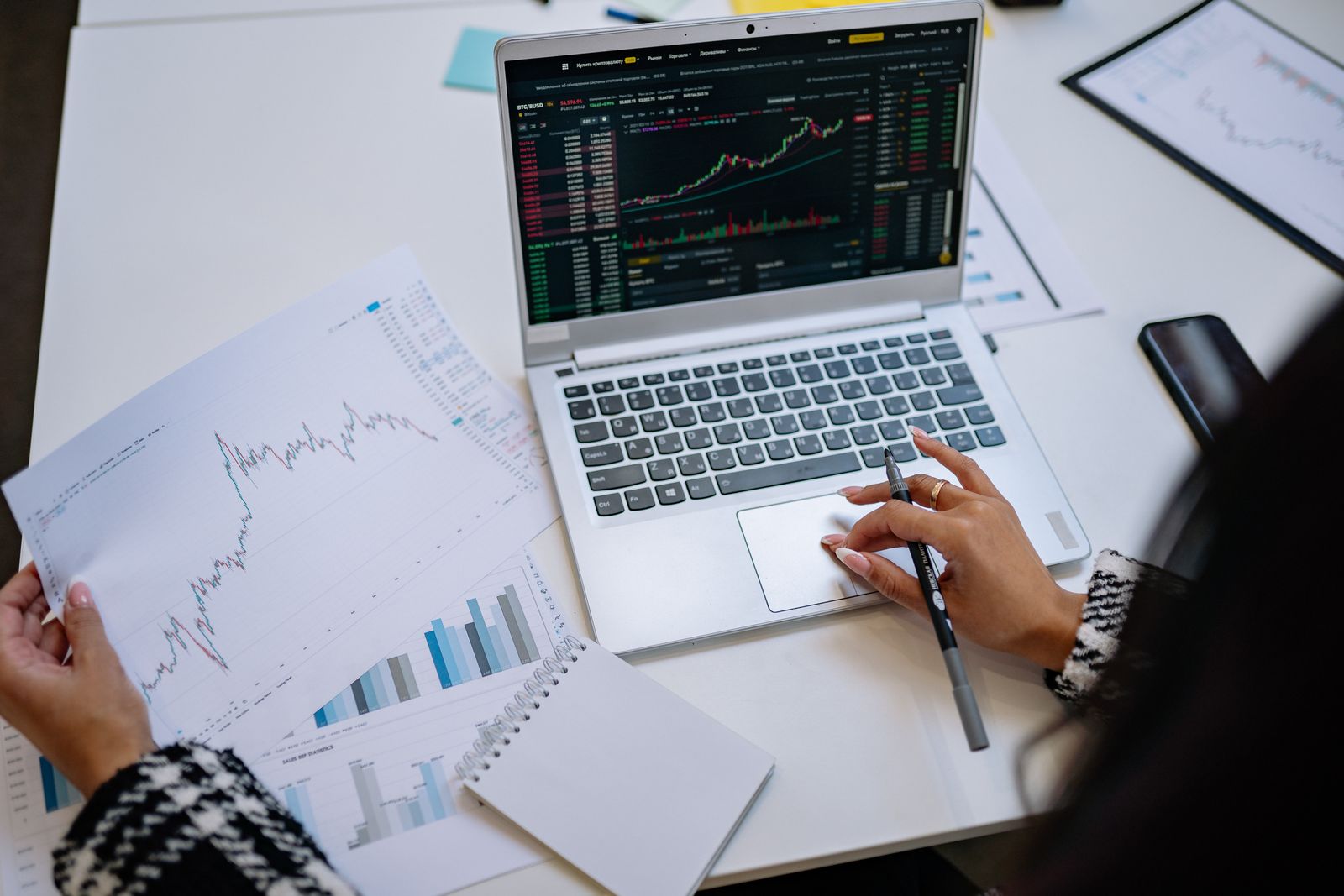 Business analysis with financial charts on a laptop.